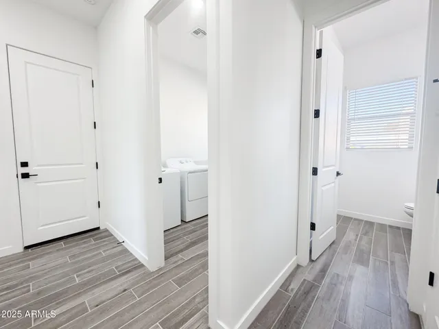 an empty room with ceiling fan and windows