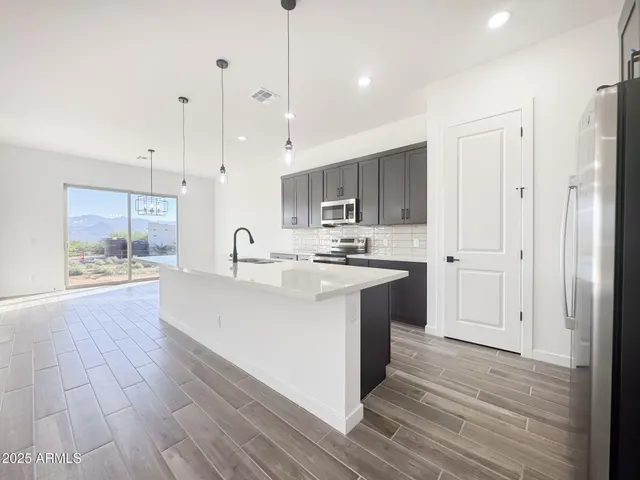 a large kitchen with kitchen island a sink stainless steel appliances and cabinets