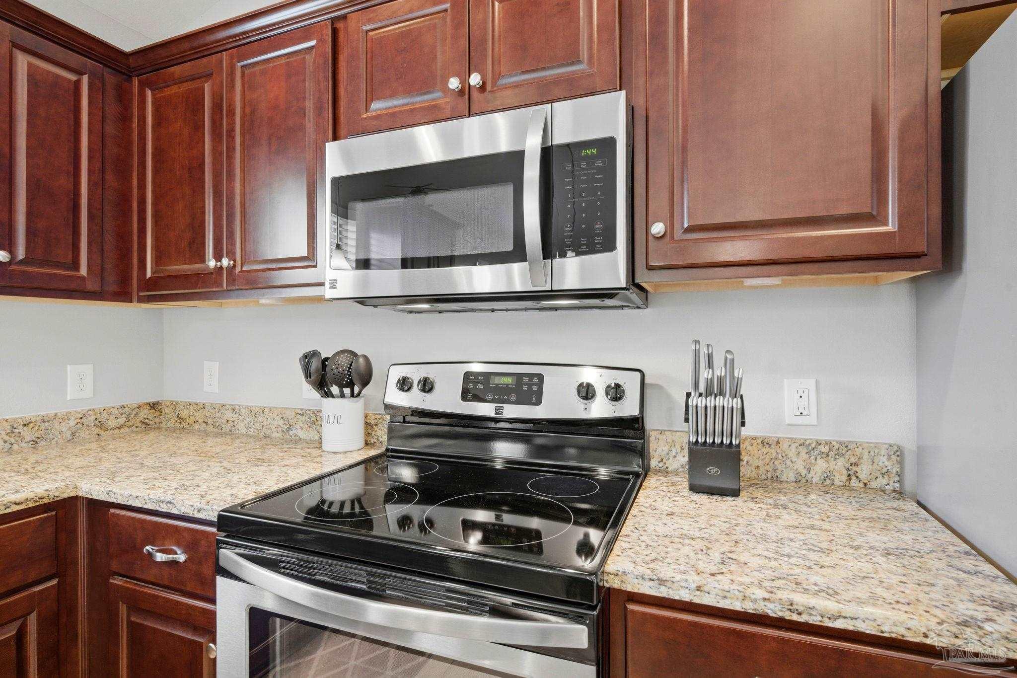 3859 Adams Road Pace, FL 32571 - Photo 11 of 26 a kitchen with granite countertop a stove and a microwave