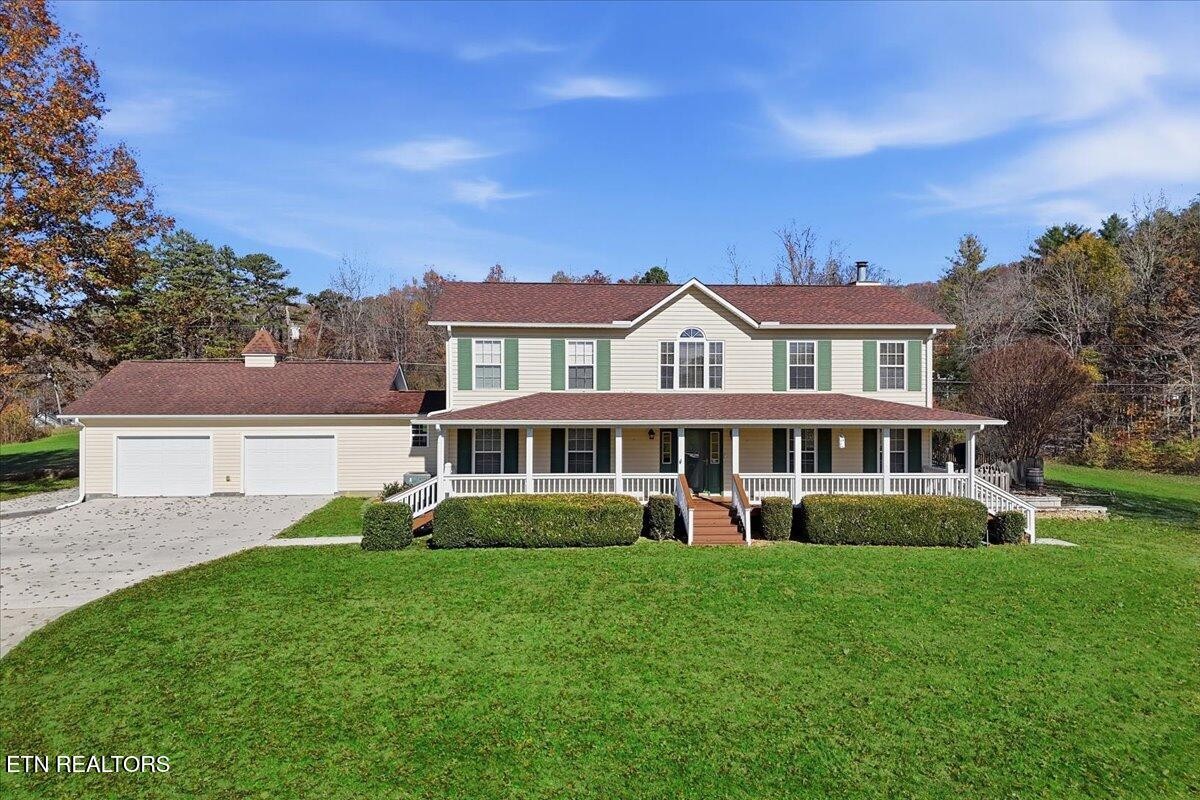 a front view of a house with a yard and trees