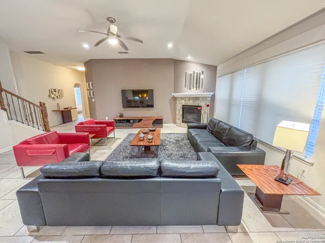 a living room with furniture a fireplace and a window