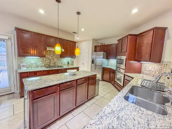 a kitchen with stainless steel appliances granite countertop sink stove and large window