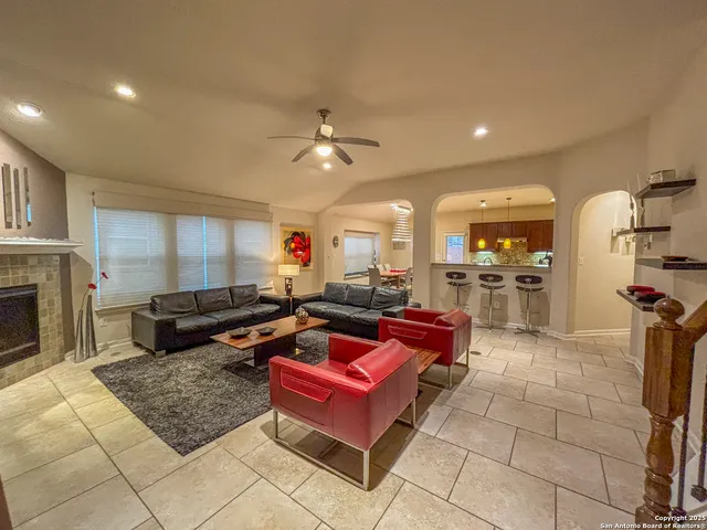 a living room with furniture a fireplace and kitchen view