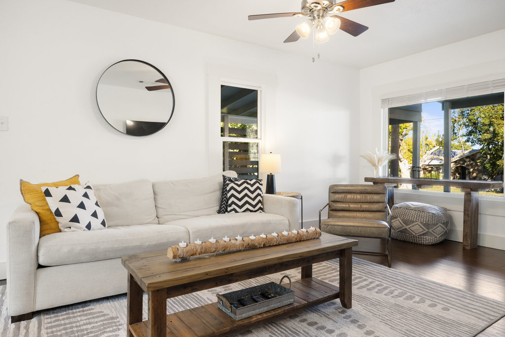 Living room with healthy amount of natural light, wood finished floors, and a ceiling fan