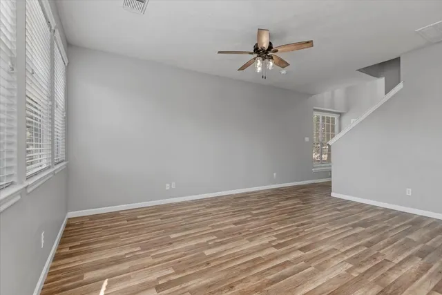 a view of a room with wooden floor and ceiling fan