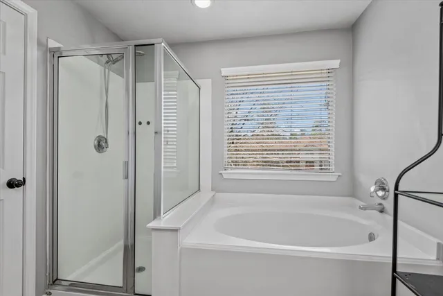 a white bath tub sitting next to a shower