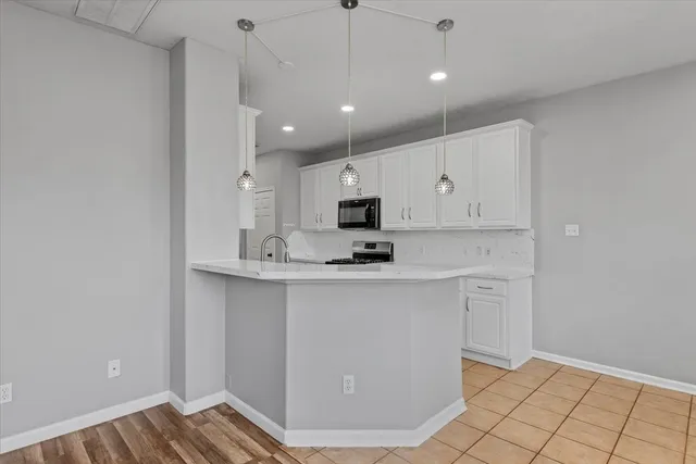 a view of kitchen with stainless steel appliances granite countertop cabinets and wooden floor