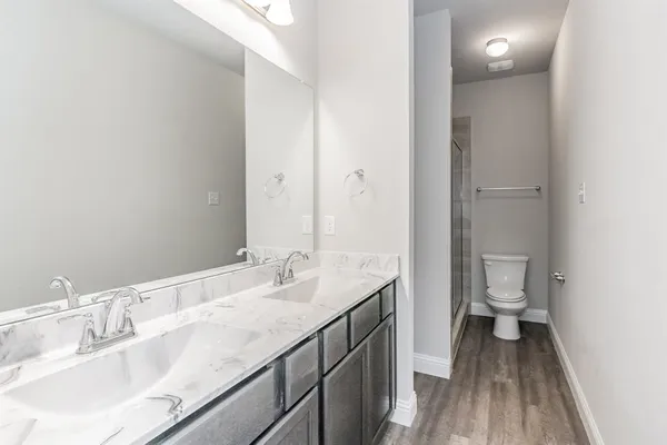 a bathroom with a granite countertop sink a toilet and a large mirror
