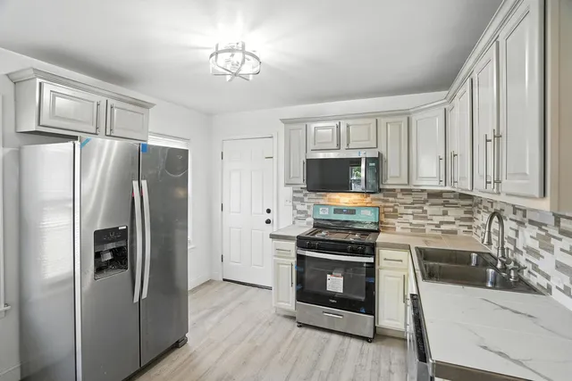 a kitchen with stainless steel appliances a stove microwave and a refrigerator
