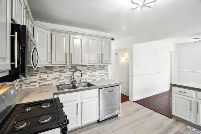 a kitchen with stainless steel appliances white cabinets and a sink