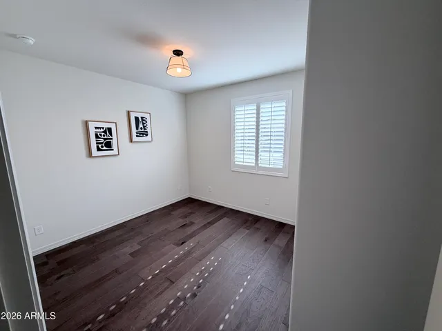 an empty room with wooden floor and window
