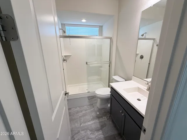 a bathroom with a granite countertop sink toilet and shower