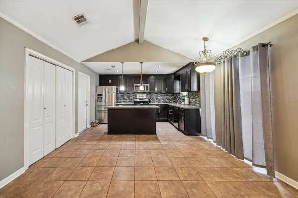 a large kitchen with kitchen island a sink stainless steel appliances and cabinets