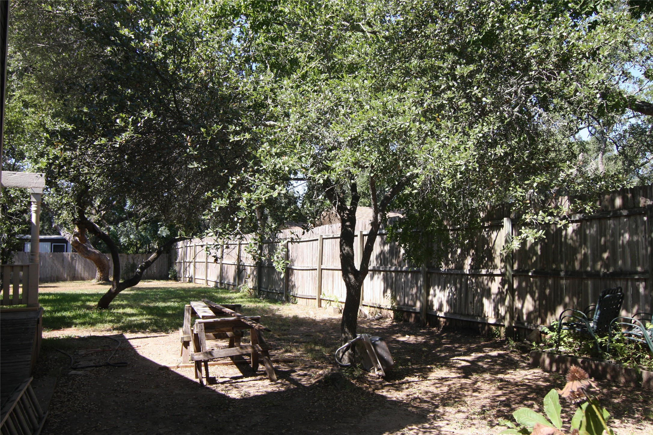 7806-7804 Indian Ridge Drive Austin, TX 78737 - Photo 15 of 40 a view of a backyard with table and chairs and a tree