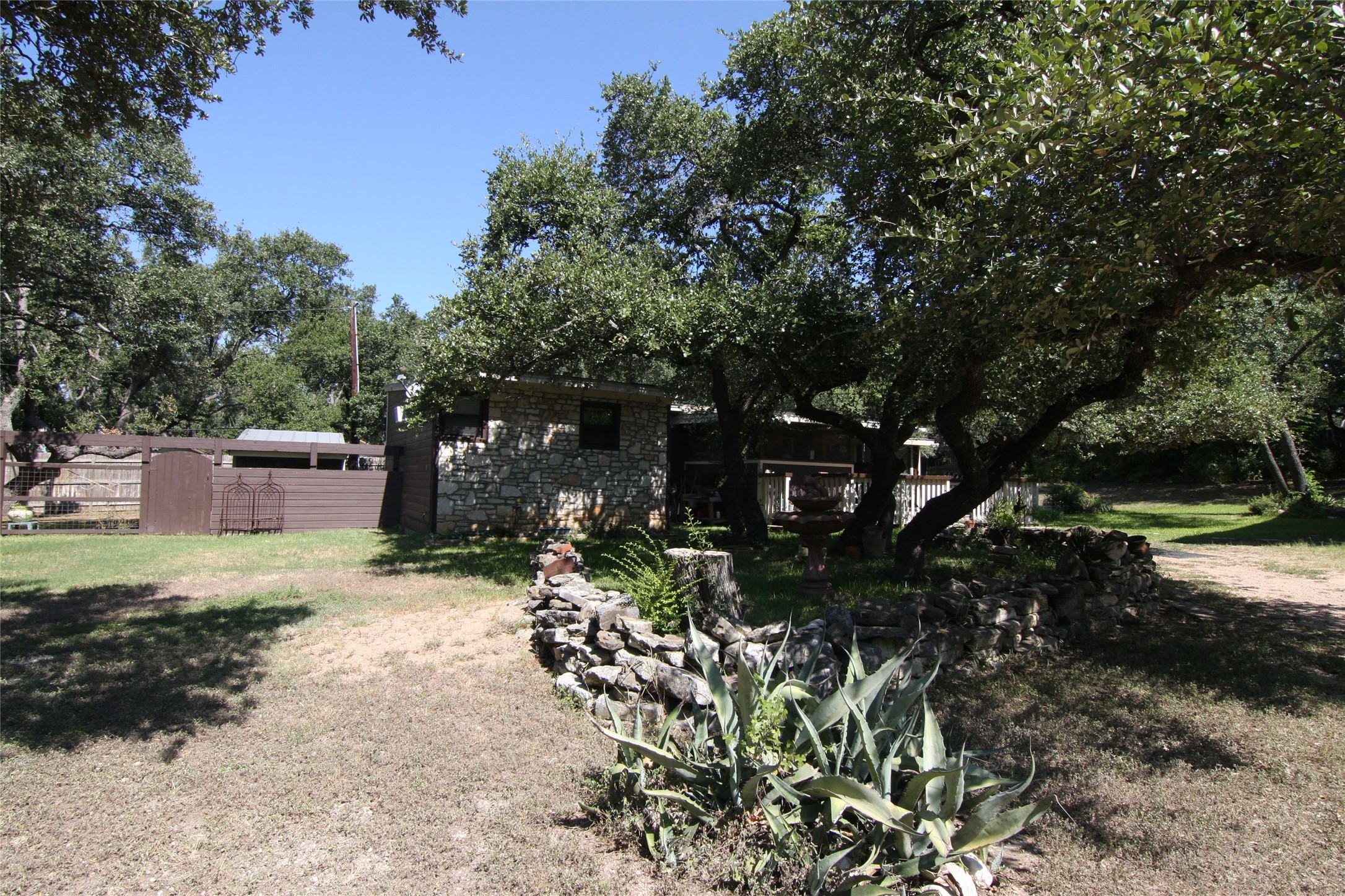 7806-7804 Indian Ridge Drive Austin, TX 78737 - Photo 4 of 40 a view of a backyard with plants and trees