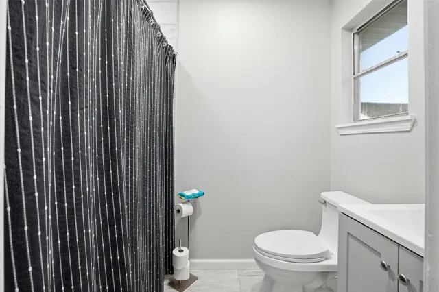 a white toilet sitting next to a shower curtain
