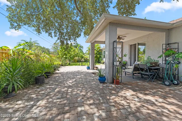a view of backyard with outdoor seating and plants