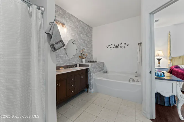 a spacious bathroom with a tub sink and mirror