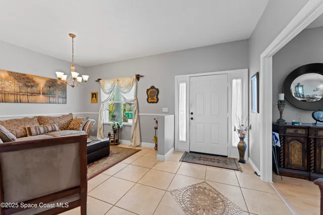a living room with furniture a window and a chandelier