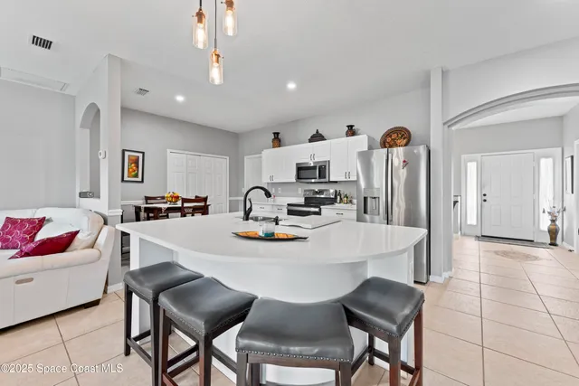 a view of kitchen with dining area and chandelier