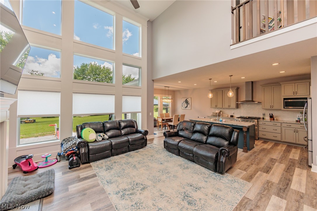 Living room with a towering ceiling and light hardwood / wood-style floors