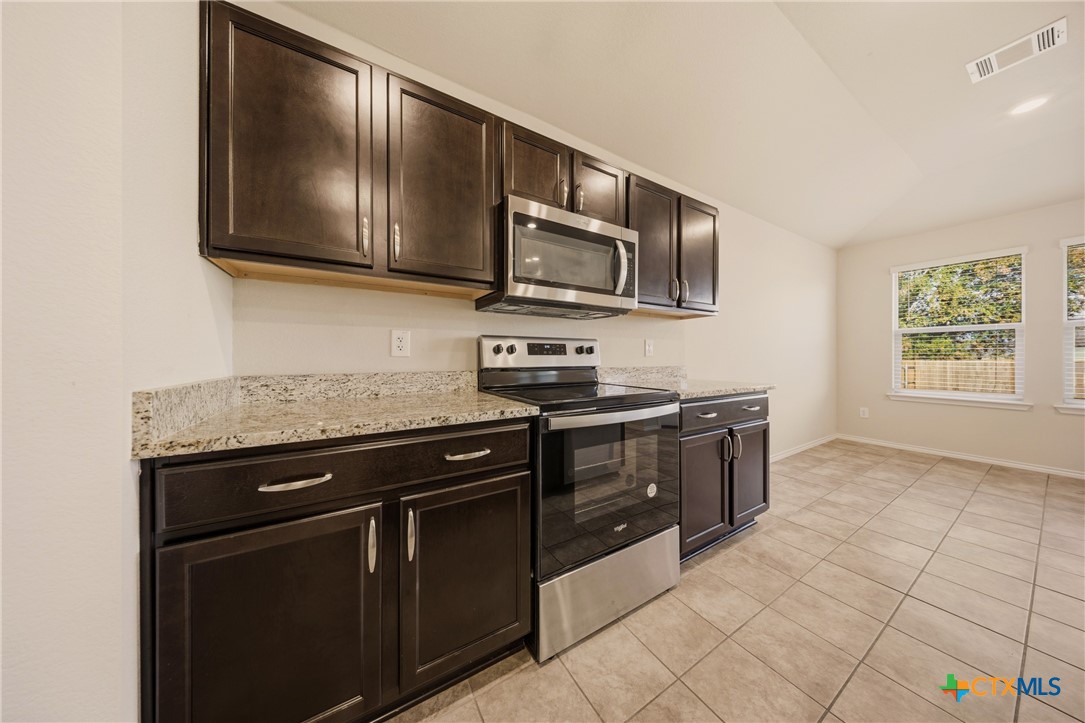 9506 Falme Lane Killeen, TX 76542 - Photo 4 of 27 a kitchen with stainless steel appliances granite countertop a stove microwave and sink