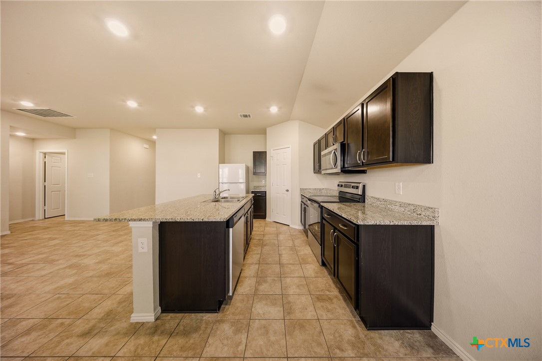 9506 Falme Lane Killeen, TX 76542 - Photo 5 of 27 a large kitchen with stainless steel appliances kitchen island granite countertop a large counter top and oven