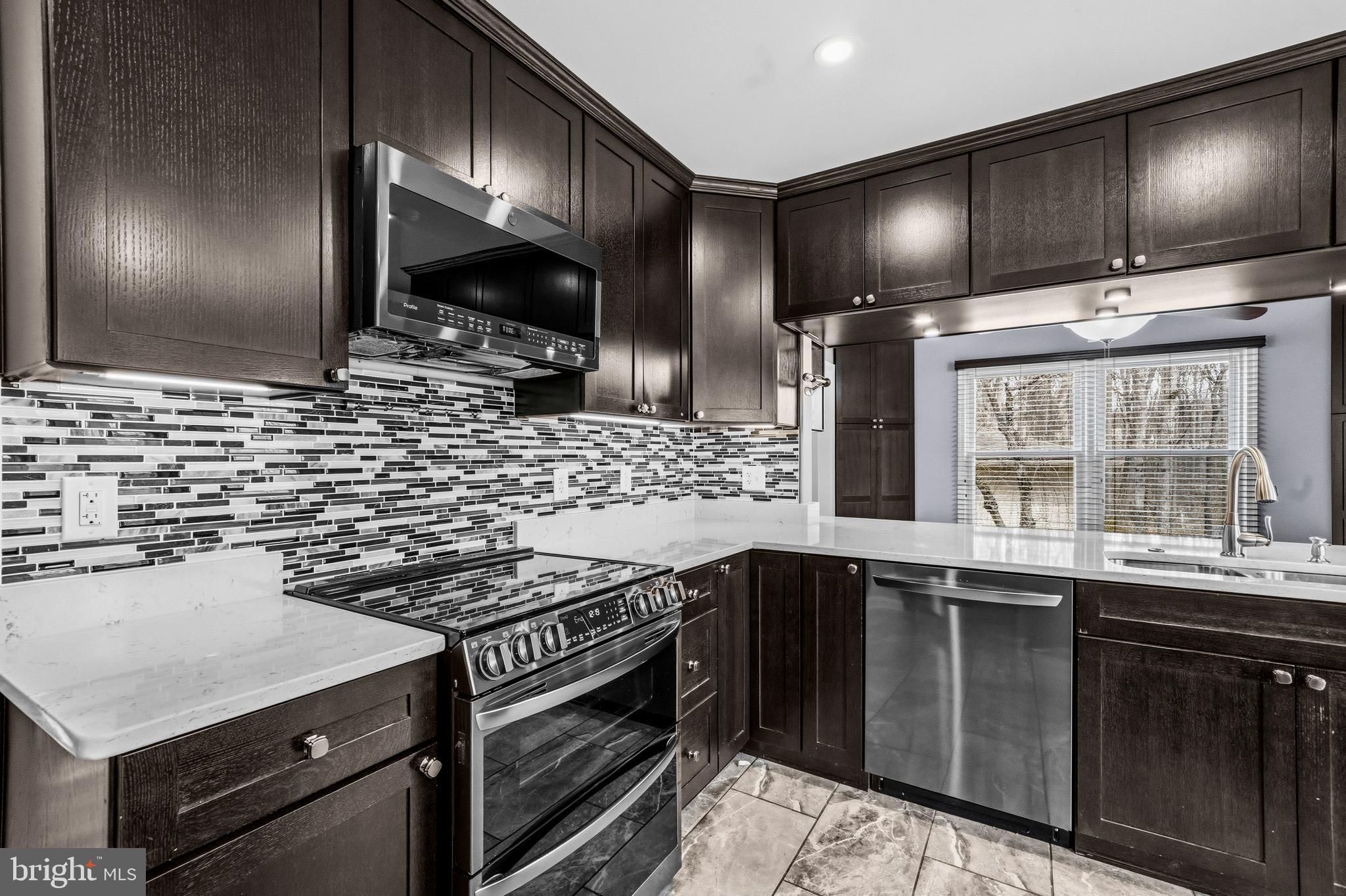 7201 Neaptide Lane Burke, VA 22015 - Photo 15 of 75 a kitchen with stainless steel appliances a sink stove and cabinets