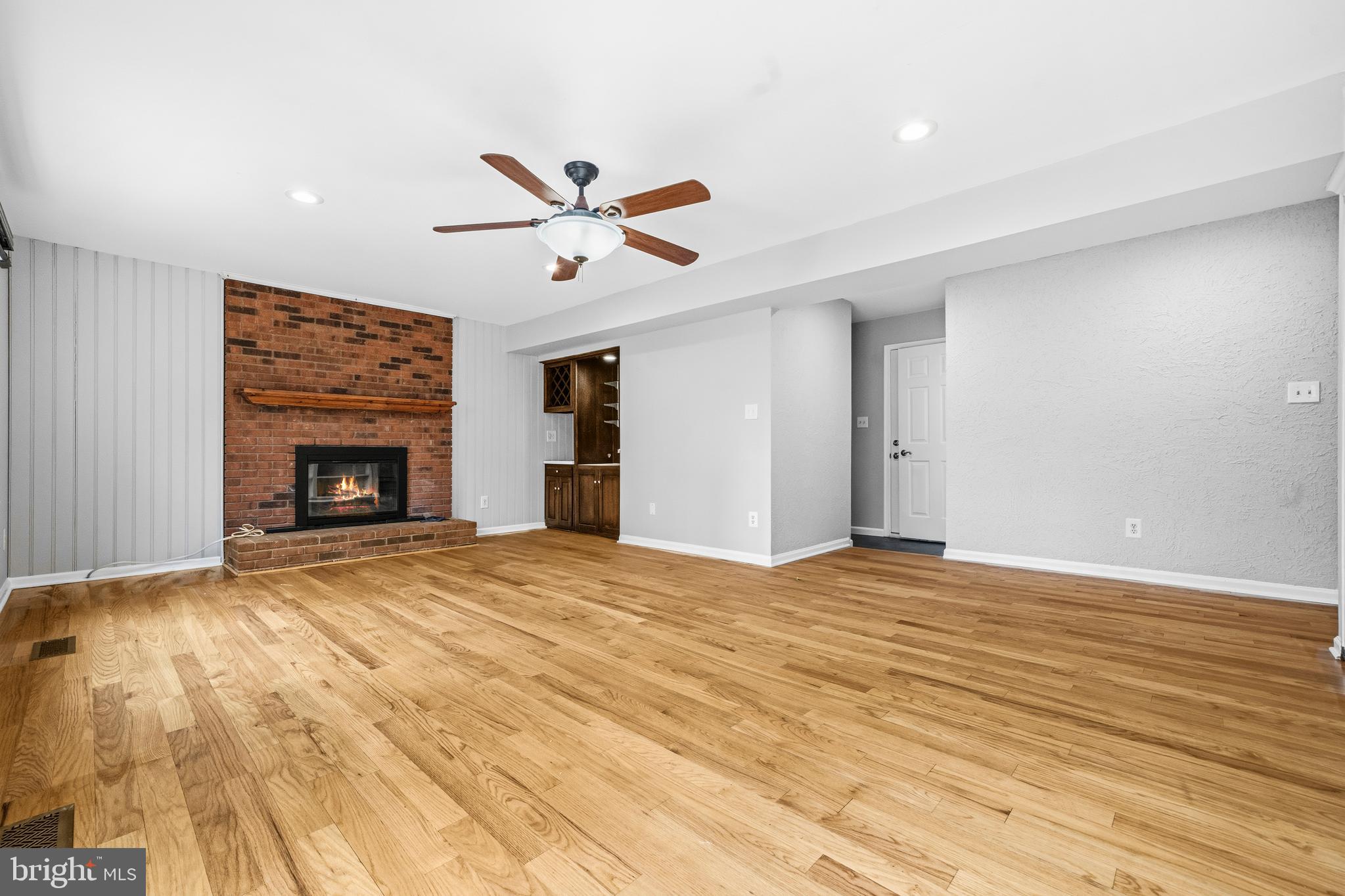 7201 Neaptide Lane Burke, VA 22015 - Photo 25 of 75 a view of empty room with wooden floor and fireplace