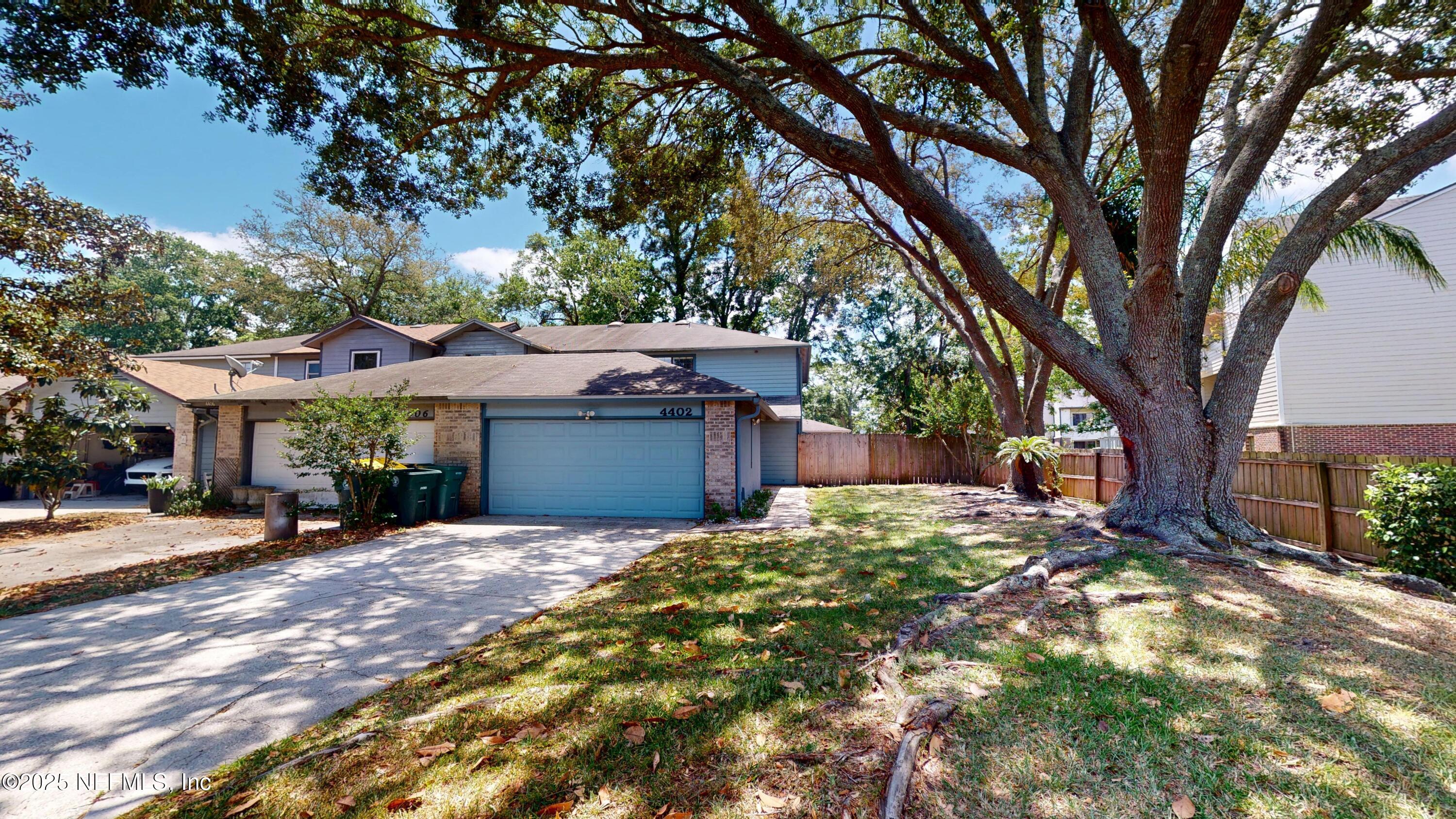 a front view of a house with a tree in a yard