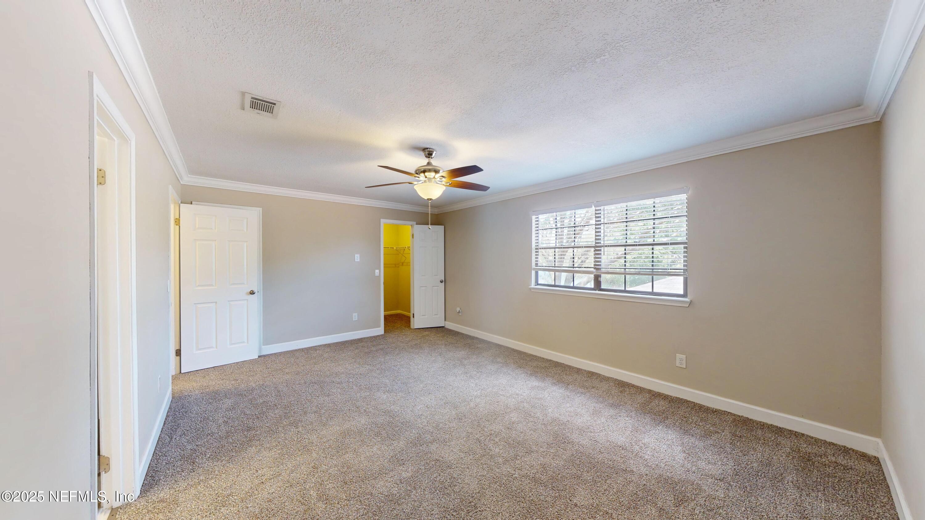 4402 Peppermill Place Jacksonville, FL 32257 - Photo 16 of 26 an empty room with a chandelier fan and windows