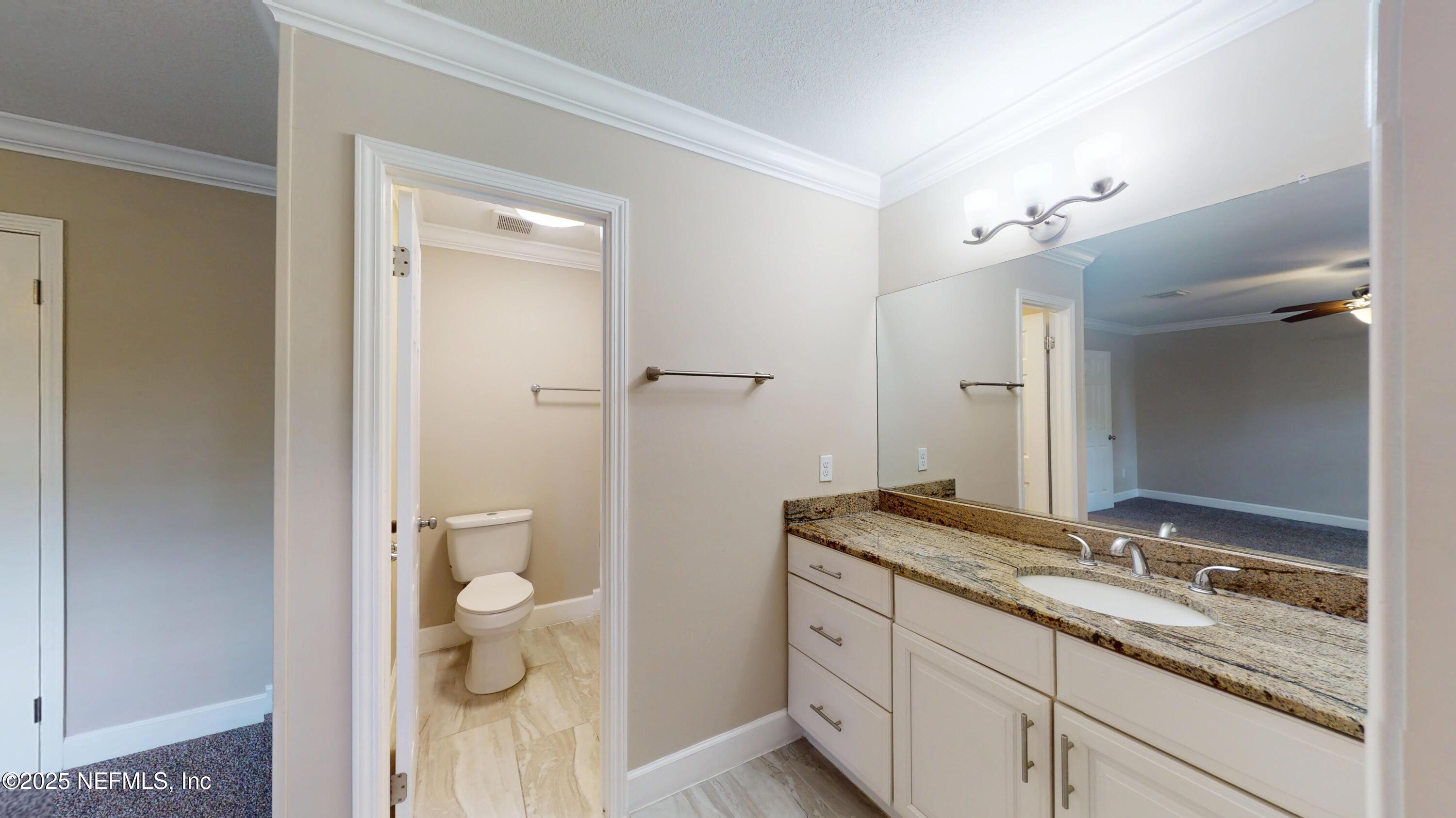 4402 Peppermill Place Jacksonville, FL 32257 - Photo 19 of 26 a bathroom with a granite countertop sink a toilet and shower