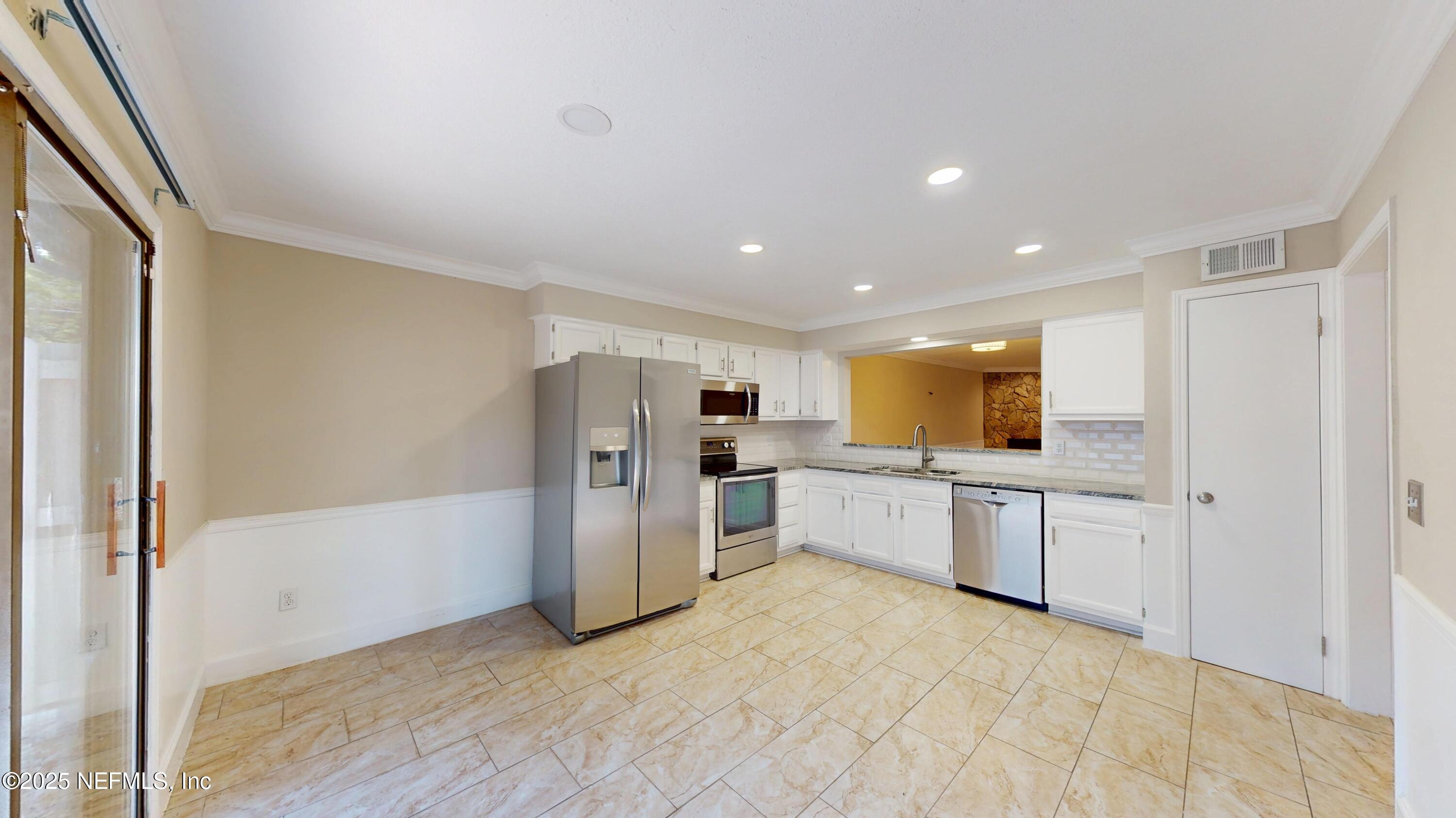 4402 Peppermill Place Jacksonville, FL 32257 - Photo 5 of 26 a large white kitchen with a refrigerator a microwave and a sink