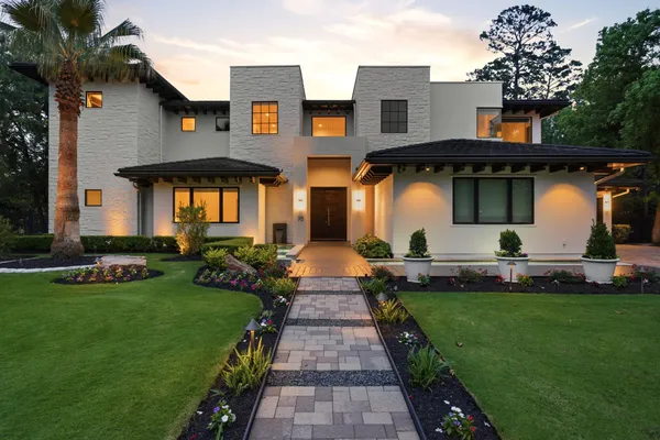 a front view of a house with a garden and plants