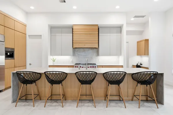 a large kitchen with stainless steel appliances granite countertop a large counter top a sink a stove and a refrigerator