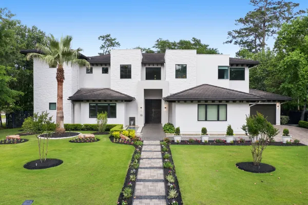 a front view of a house with a yard and trees