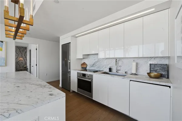 a kitchen with stainless steel appliances granite countertop a stove a sink and a refrigerator