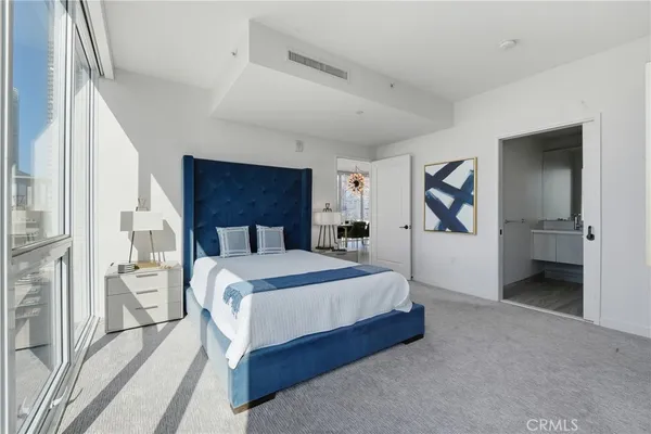 a spacious bedroom with a bed and a cabinets