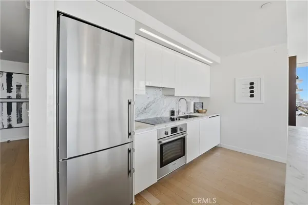a kitchen with stainless steel appliances a refrigerator and a stove top oven