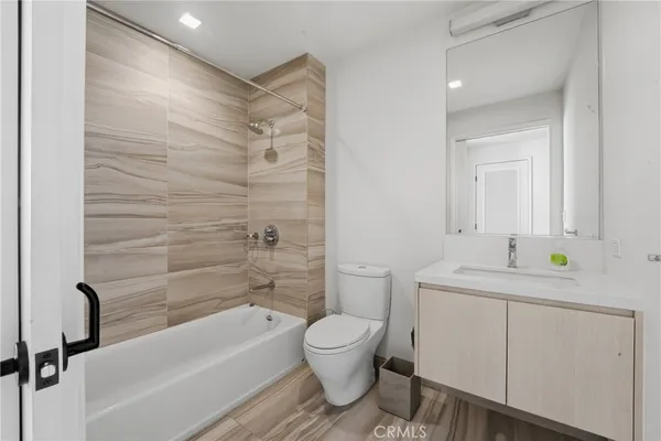 a bathroom with a granite countertop sink toilet a mirror and shower