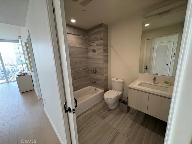 a bathroom with a granite countertop sink toilet and shower