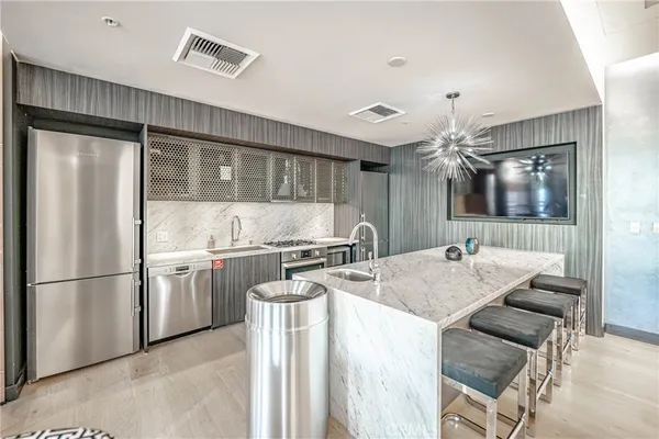 a kitchen with stainless steel appliances granite countertop a sink refrigerator and cabinets