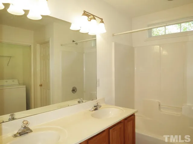 a bathroom with a sink shower and a mirror