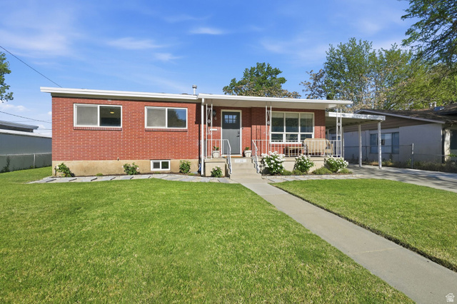 66 South 425 West Bountiful, UT 84010 - Photo 1 of 25 Brick exterior with a covered front porch featuring white railing, a concrete walkway, and a manicured lawn