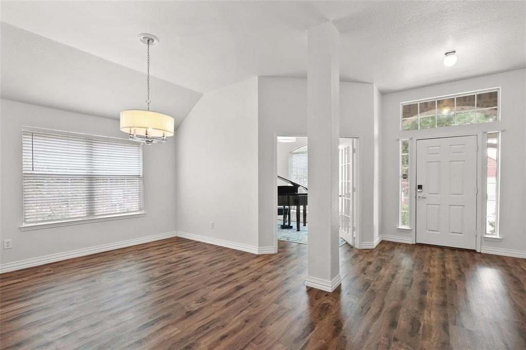 5961 Cheyenne Way Frisco, TX 75034 - Photo 2 of 33 Foyer and dining area featuring wood-finish flooring, a contemporary drum pendant light, vaulted ceiling, and an entry door with sidelights and transom window