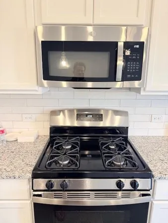 a stove top oven sitting inside of a kitchen