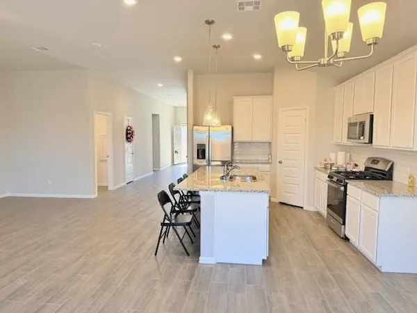 a kitchen with stainless steel appliances kitchen island hardwood floor sink stove and cabinets