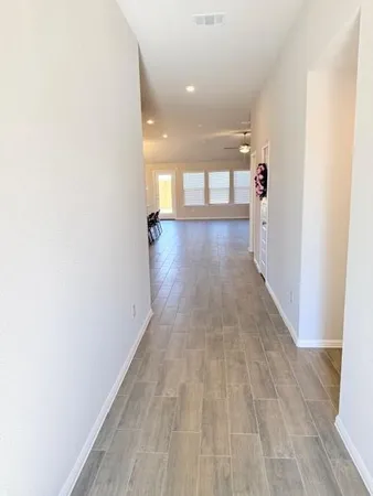 a view of a hallway with wooden floor