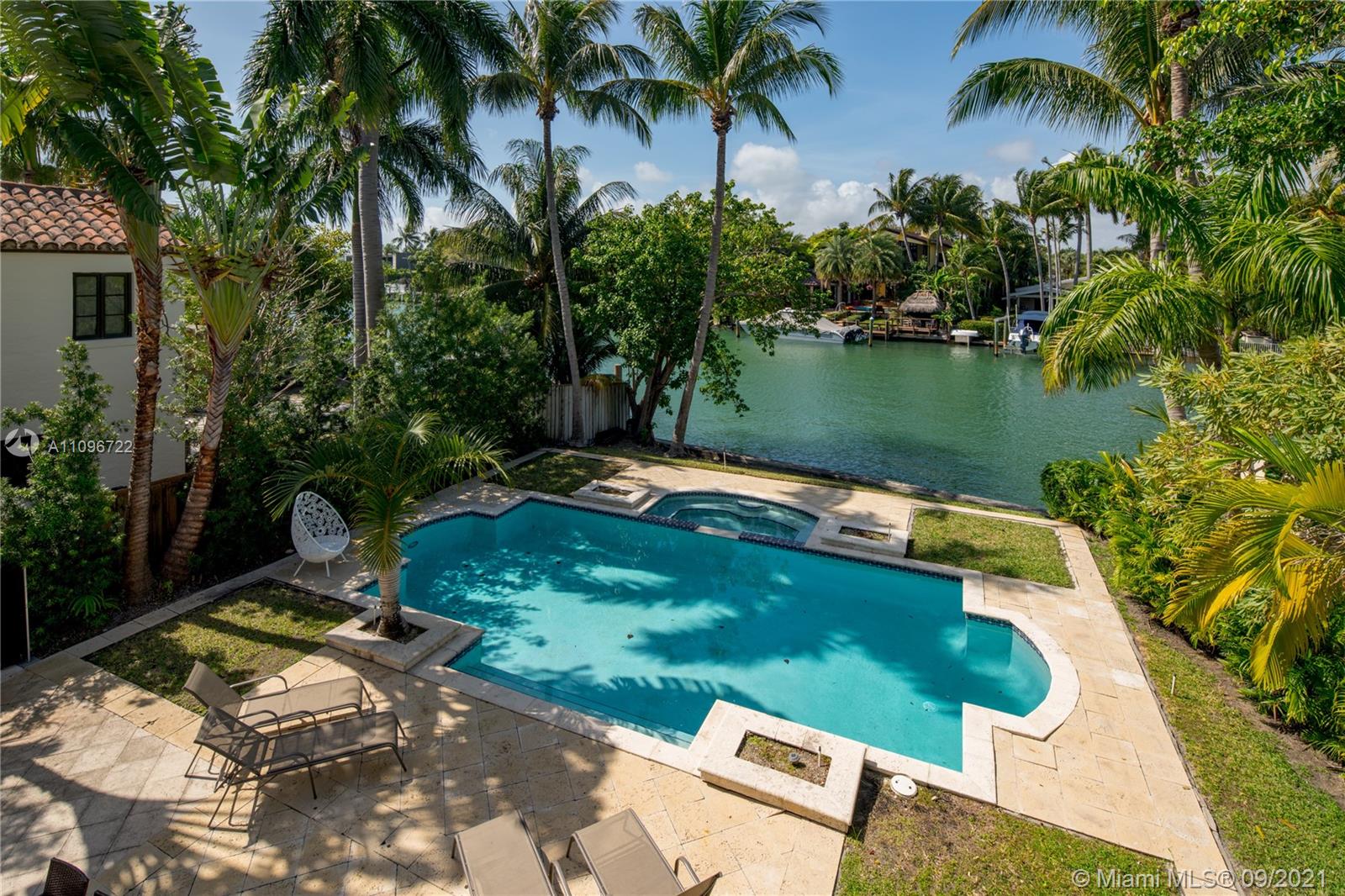 4900 Pine Tree Drive Miami Beach, FL 33140 - Photo 16 of 64 a view of a swimming pool with a yard and lake view