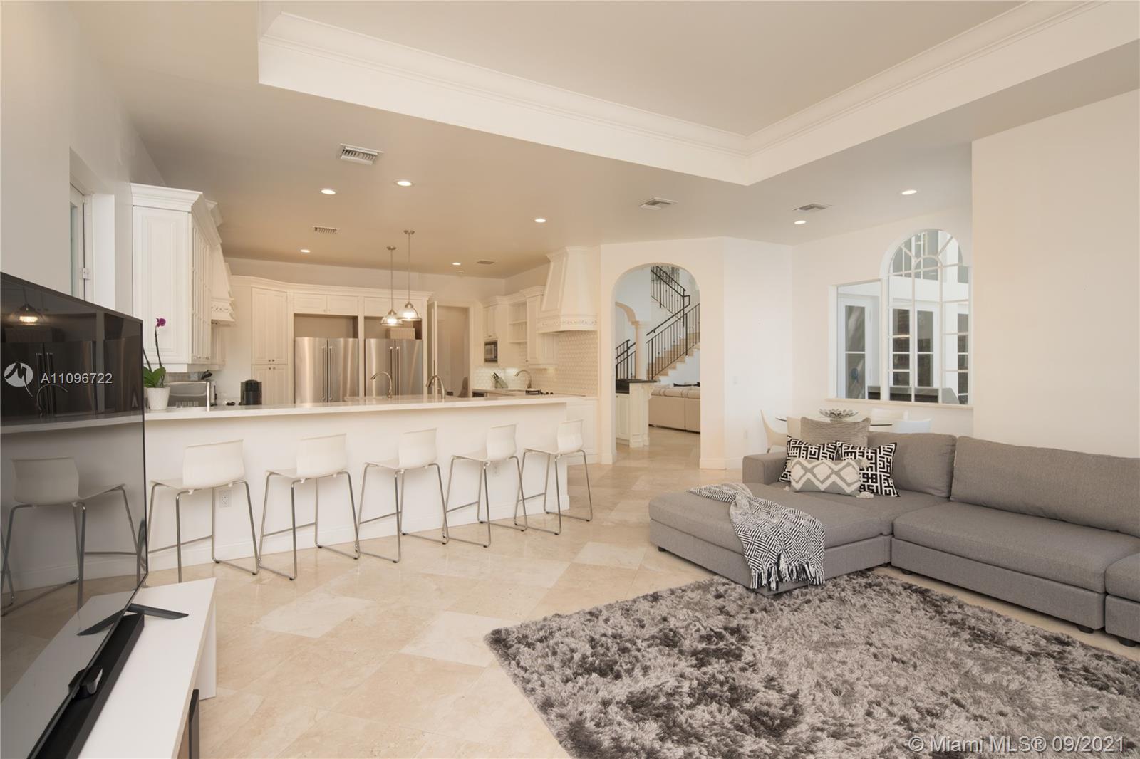 4900 Pine Tree Drive Miami Beach, FL 33140 - Photo 20 of 64 a living room with furniture and a dining table with kitchen view